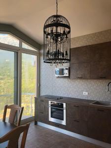 una cocina con una lámpara de araña colgada sobre una estufa en Апартаменты Anturage с отдельным входом, en Dobra Voda