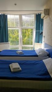 1 dormitorio con 2 camas, cortinas azules y ventana en ID Hostel Rostov-on-Don, en Rostov-on-Don