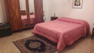 1 dormitorio con cama rosa y espejo en My Vintage Home, en Bassano in Teverina