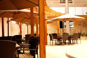 um pátio exterior com mesas, cadeiras e guarda-sóis em SG Premium Resort em Arusha