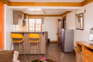 a kitchen with two orange stools in a room at Marble Arch Hotel in Nairobi