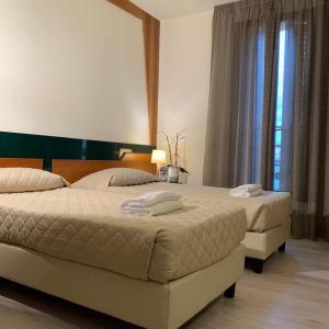a bedroom with two beds and a large window at HOTEL DOZZA in Dozza