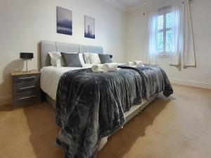 a bedroom with a large bed with two towels on it at Linburn House Apartment in Dunfermline