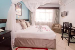 a bedroom with a bed with a stuffed animal on it at Marble Arch Hotel in Nairobi