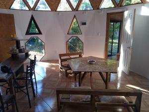 Zimmer mit einem Tisch, Stühlen und Fenstern in der Unterkunft Casa domo San Fabián de Alico in San Fabián de Alico