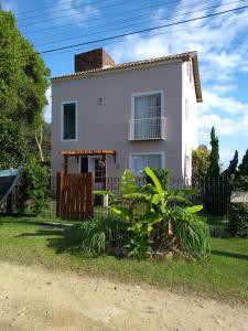 una casa blanca con una valla delante en Solar Lisboa 100 m da Praia com vista para mar en Balneário Camboriú