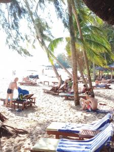 a group of people on a beach with palm trees at Phu Quoc Beach Guesthouse in Phú Quốc