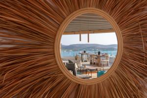 a circular window in a wooden wall with a view of a house at Sunset View Hotel in Parikia