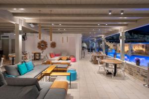 a room with couches and tables and a pool at Sunset View Hotel in Parikia