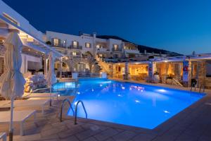 a large swimming pool in front of a hotel at night at Sunset View Hotel in Parikia