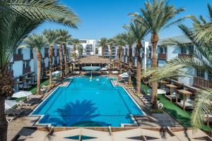 vista aerea su una piscina del resort con palme di G hotel a Eilat