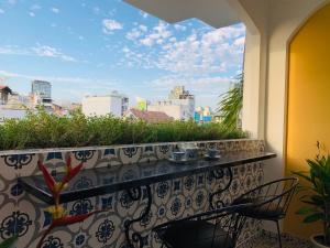 a balcony with a table and chairs and a view of the city at Chez Mimosa Local in Ho Chi Minh City