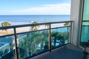 a balcony with a view of the beach and the ocean at New Ocean Front Corner Unit in Myrtle Beach