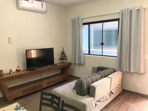 a living room with a couch and a flat screen tv at Casa - Próximo a UFSC e Centro - 5KM # in Florianópolis
