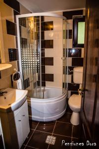 a bathroom with a tub and a sink and a toilet at Casa Dora in Moieciu de Sus
