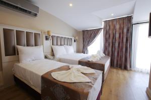 a hotel room with two beds and a window at Villa Sweet Hotel in Istanbul