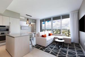 a kitchen and living room with a couch and a table at Ocean Breeze Retreat - Pool Gym Access Views in Hallandale Beach