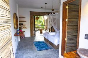 - une chambre avec un lit et une porte donnant sur une cour dans l'établissement Bikini Beach House, à Puerto Escondido