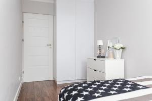 sypialnia z czarno-białym łóżkiem i komodą w obiekcie Apartament Forest - Parking - Praia Apartments Sopot Aquapark w mieście Sopot