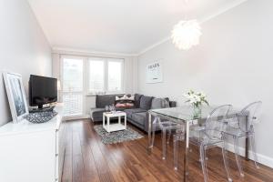 salon ze stołem i kanapą w obiekcie Apartament Forest - Parking - Praia Apartments Sopot Aquapark w mieście Sopot