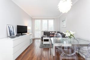 Biały salon ze szklanym stołem i kanapą w obiekcie Apartament Forest - Parking - Praia Apartments Sopot Aquapark w mieście Sopot