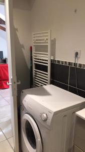 Una lavadora blanca en una habitación con pared en Vichy, en Vichy