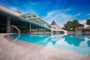 una piscina en un complejo con cielo azul en The Royal Gems Golf Resort en Nakhon Pathom