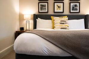 a bedroom with a large bed with pillows at voco Oxford Thames by IHG in Oxford