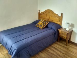 1 dormitorio con cama azul y mesita de noche en Casa Blanca, en Algimia de Alfara