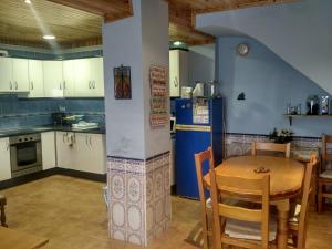 cocina con mesa y nevera azul en Casa Blanca, en Algimia de Alfara