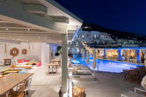 eine Terrasse mit Tischen und Stühlen sowie einem Pool in der Unterkunft Sunset View Hotel in Parikia