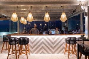 a man standing at a bar in a restaurant at Sunset View Hotel in Parikia