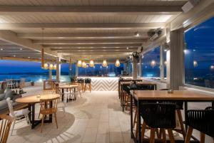 a restaurant with tables and chairs and a view of the ocean at Sunset View Hotel in Parikia