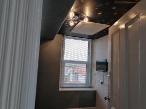 Cette chambre dispose d'un plafond avec une fenêtre et une fenêtre. dans l'établissement Sunrise Apartments, à Llandudno