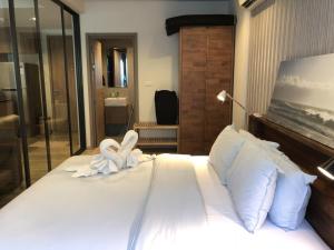 a bedroom with a large bed with towels on it at Raincondo Ampere in Cha Am