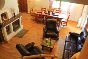 a living room with leather furniture and a fireplace at Zagroda Lipowiec in Polańczyk