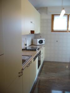 eine Küche mit einem Herd und einer Mikrowelle in der Unterkunft Aparthotel Feeling at Home in Castenaso