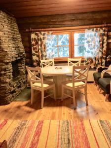een eetkamer met een tafel en stoelen en een open haard bij Mäntytupa Lodge in Syöte