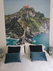 1 dormitorio con 1 cama y una pintura de la costa en La Concordia, en Bilbao