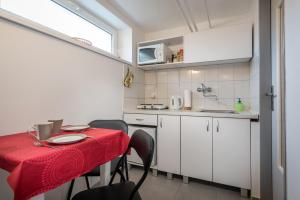 a small kitchen with a table with a red table cloth at Apartment Highway in Poprad