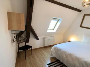 Un dormitorio con una cama y una ventana y una silla. en Le gite 6 - Le Château du Haut-Koenigsbourg, en Sélestat