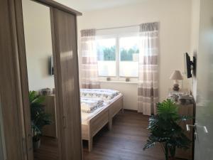 a bedroom with a bed in front of a window at WaldEck in Hartenholm