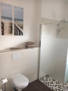 a bathroom with a toilet and a picture of the beach at WaldEck in Hartenholm