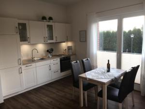 a kitchen with a table and chairs and a kitchen with a sink at WaldEck in Hartenholm