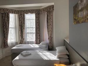 a bedroom with a bed and a window at Ullswater Hotel in Bournemouth