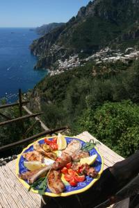 une assiette de denrées alimentaires contenant de la viande et des légumes sur une table dans l'établissement Fattoria La Tagliata, à Positano