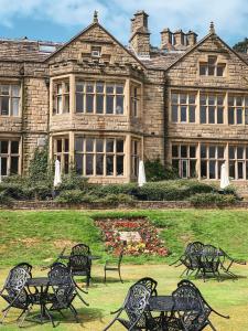 a group of tables and chairs in front of a building at Hollins Hall Hotel, Golf & Country Club in Bradford