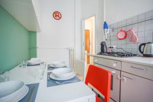 eine Küche mit einer Theke und einem roten Stuhl in der Unterkunft IMHOME - Muratori in Mailand