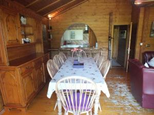 a dining room with a table and chairs at Walnut Log Cabin in Swanage