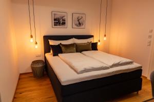 a bedroom with a large bed with white sheets and pillows at LUVA Resorts Kappl - Chalet K in Kappl